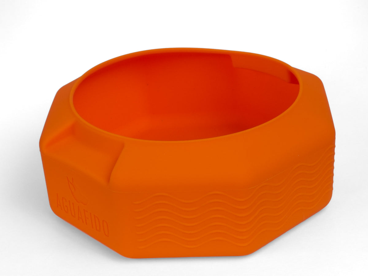 An orange silicone pet bowl with a textured wavy pattern on the front and a debossed AguaFido logo on the lower left side, shown on a clean white background.